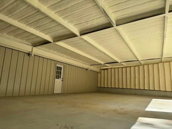 Closed-cell spray foam insulation applied to the metal roof deck and wood-framed walls of a drive-in porch addition in Tomball, TX.