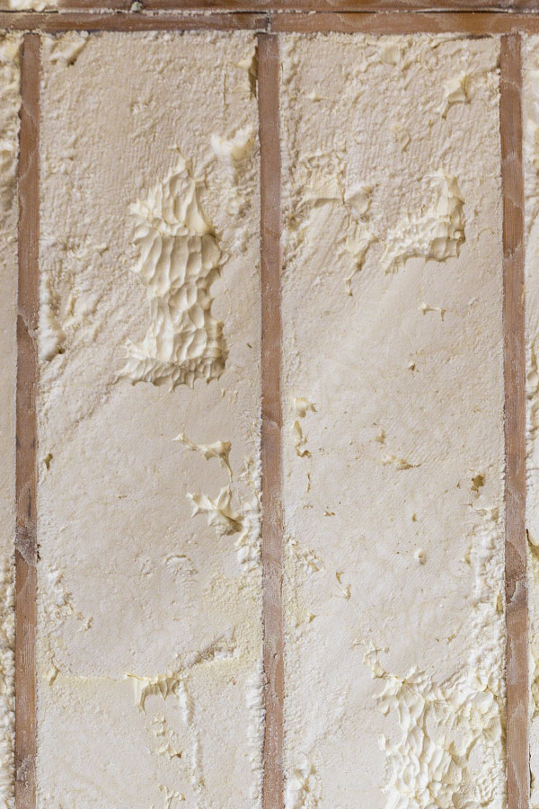 Close-up of open-cell spray foam insulation showing soft spongy texture applied inside a North Houston TX home